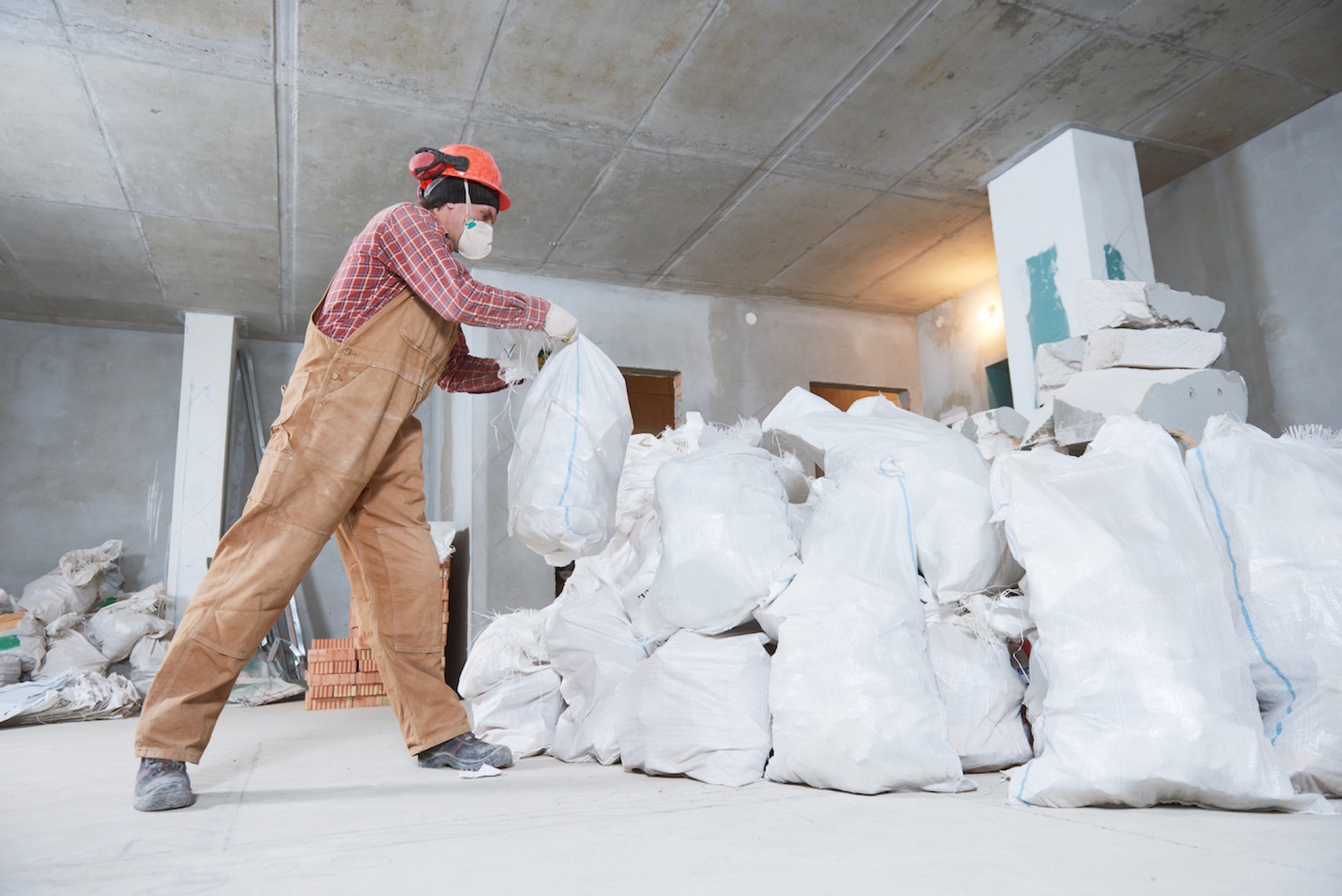 man placing construction debris in bags